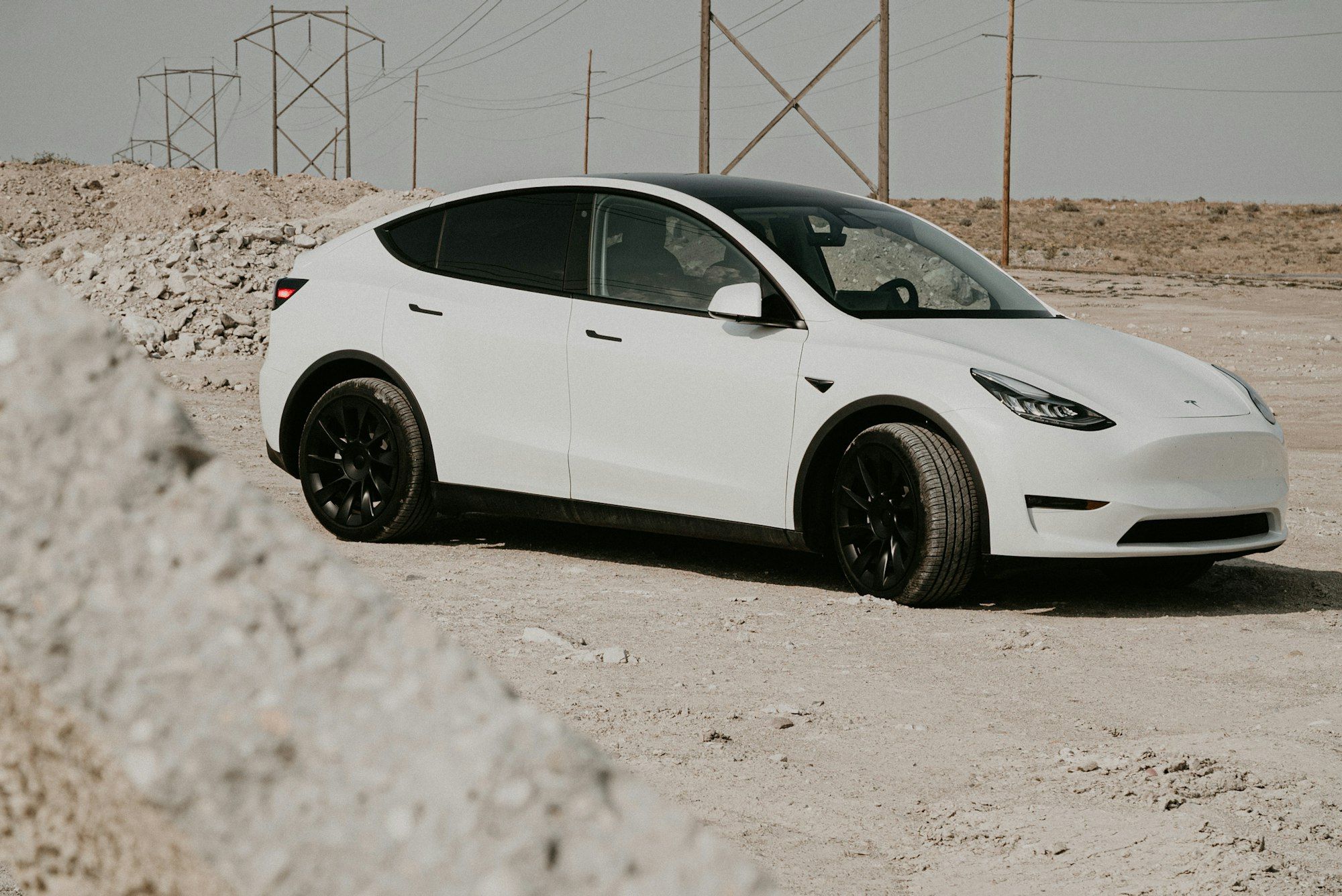 A white electric SUV parked on a dirt road